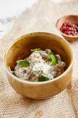 Traditional Georgian appetizer - sacivi. Georgia dish from cooked chicken in walnut sauce with herbs and spices. Authentic starter food from chicken meat in sauce in rustic style.