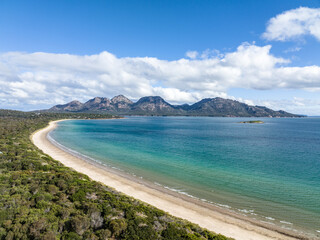 4k high angle aerial drone view of Muirs Beach near Coles Bay with the famous Hazards mountain...