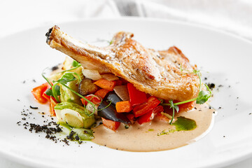 Roasted pork steak with vegetables garnish and sauce. Bone-in ribeye pork chops. Main course of pork in rustic style.