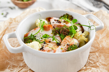 Healthy eating: steamed vegetables with salmon. Healthy salmon meal with broccoli and cauliflower. Casserole with fish and broccoli for lunch. Broccoli dish in diet menu. Cooked fish and veggies.