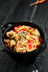 Chicken fried rice on wok. Asian food - fried rice with vegetables, egg and chicken on dark table. Wok menu on black wood background. Traditional chinese food.