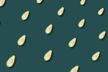 Colorful pattern of fresh avocados on green background with shadows. Top view. Flat lay. Pop art design