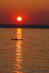 A vertical shot of a boat on the Puget Sound during a beautiful sunset in Washington