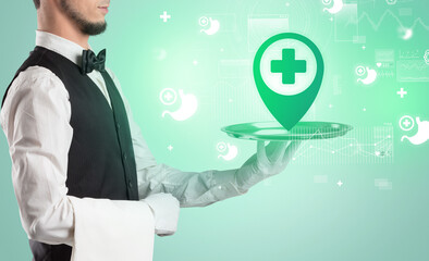 Handsome young waiter in tuxedo holding healthcare icons on tray