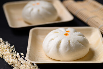 Steamed Chinese bun stuffed with minced pork, egg yolk or sweet on natural plate, Asian food