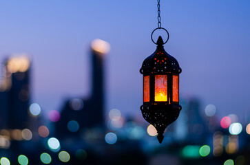 Hanging lantern with night sky and city bokeh light background for the Muslim feast of the holy...