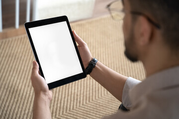 Man looking at blank mockup screen holding tablet digital device in hand