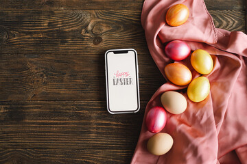 Happy Easter. Phone and stylish color easter eggs flat lay on rustic table. Natural dyed colorful easter eggs on wooden background. Space for text