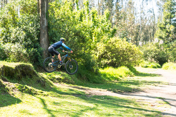 Mountain biker jumping on his bike on a trail in the woods