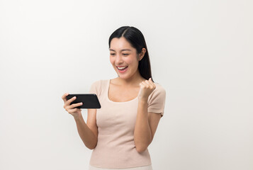 Fototapeta premium Excited Beautiful young asian woman using smartphone mobile standing on isolated white background. Playing game on smartphone winning victory moment. Very happy enjoy and fun relax time