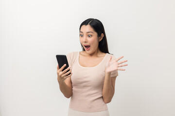 Fototapeta premium Surprised young Asian lady using mobile phone. Very Shocked face asia woman holding smartphone. Looking at cell phone screen. Victory moment. Very enjoy and fun relax time