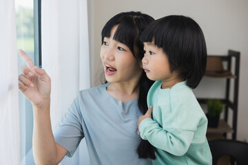 Happy Mom carry son in the house. Mother holding little boy walking around living room at home happy family moment.