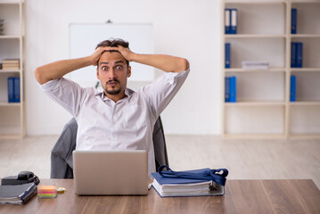 Young male employee sitting in the office