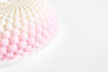 A white-pink unusual cake lies on a white plate on a light background. Delicious pastries. Valentine's Day background