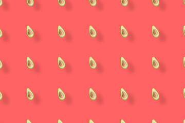 Colorful pattern of fresh avocados on red background with shadows. Top view. Flat lay. Pop art design