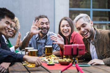 Group of young friends make Video Call in outdoors bar. Beautiful Young Diversity People drinking beer