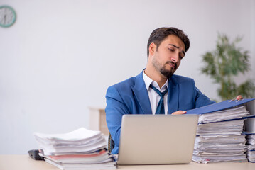 Young male employee and too much work in the office