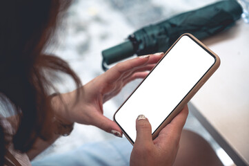 Close up women using a smartphone with an empty white screen at the cafe.