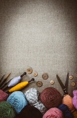 Panoramic view of composition with knitting accessories: balls of wool yarn, set of knitting needles, hooks, and other knit tools on wooden background. Long banner, top view, copy space, flat lay.