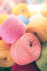 A lot of colorful wool balls of knitted yarn on a white background. The concept of handmade work,...