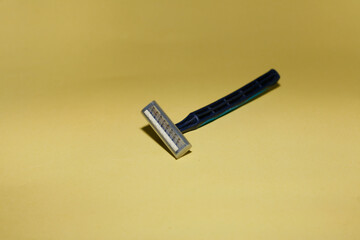 Used grungy rusty shaving razor isolated on yellow background. Close up. Copy space.