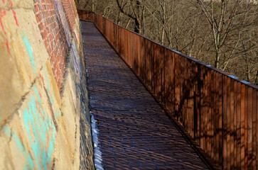 road along the baroque bastion. modern railing made of corten sheet metal. The sidewalk is paved...