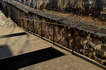 stairs and ramps for wheelchairs made of good-looking concrete. stone surfaces of paving and stairs illuminated by the sun. Rusted steel railing. boarding platform handle