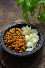 a plate of  traditional food named sambal urap  that made from fresh coconut grated with ground raw spices 