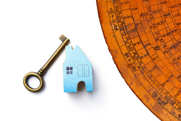 Blue wooden miniature house and antique key with old Chinese Feng Shui compass plate on white...