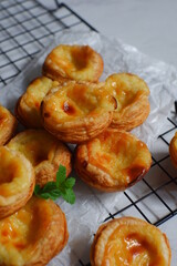 pile of egg tarts against white background 