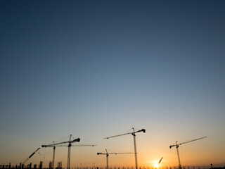 Cranes on a construction site, Silhouette of sunset