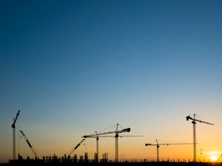 Cranes on a construction site, Silhouette of sunset