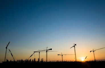 Cranes on a construction site, Silhouette of sunset