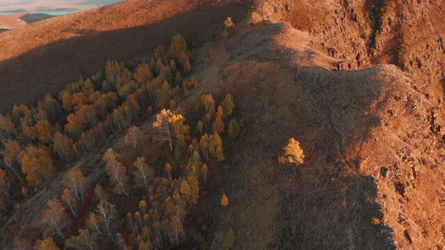 Climbing over the tops of the cliffs in the rays of the evening sun, a view from a height of the bay and mountains on the shore. Evening light and silence. Tepsey Khakassia Potroshilovo. Tepsei