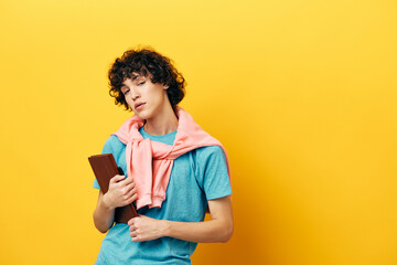 curly guy education with notepad hand gesture yellow background