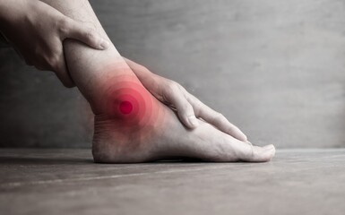 Inflammation of Asian man’s ankle joint and foot. Concept of joint pain, osteoarthritis or gout.