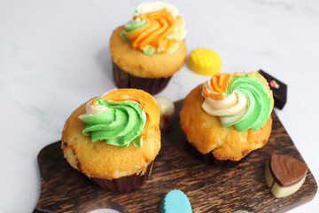 Obraz na płótnie Canvas Tiranga Cupcake or Tricolor Cupcake with Indian National Flag colors frosting. saffron or orange, white and green. The concept for Indian happy Independence or Republic day greeting card. copy space.