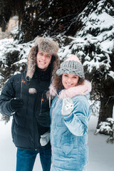 Obraz premium Man and woman playing with snow. Happy couple has fun outdoors.