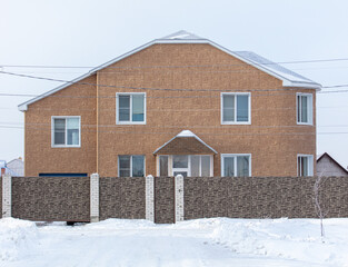 Brick cottage in the snow in winter.