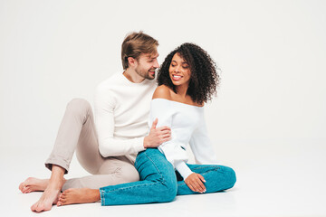 Fototapeta na wymiar Smiling beautiful woman and her handsome boyfriend. Happy cheerful multiracial family having tender moments on grey background in studio. Multiethnic models hugging. Embracing each other.Love concept