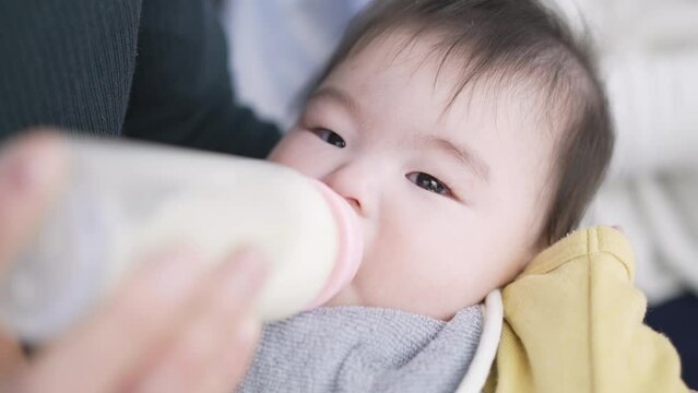 寝ながらミルクを飲むアジア人の赤ちゃん