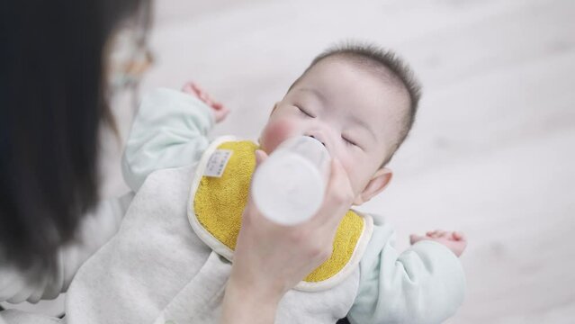 寝ながらミルクを飲むアジア人の赤ちゃん