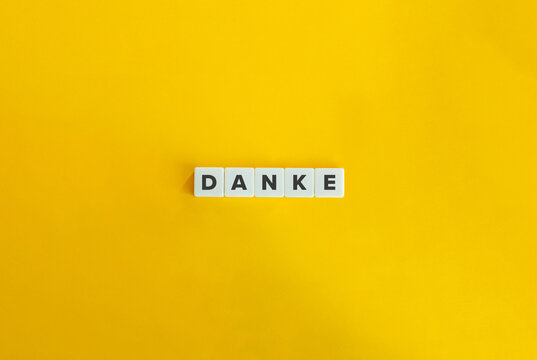 Danke Word on Letter Tiles on Yellow Orange Background. Minimal aesthetics.