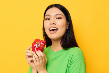 Portrait Asian beautiful young woman with a small gift box holiday yellow background unaltered