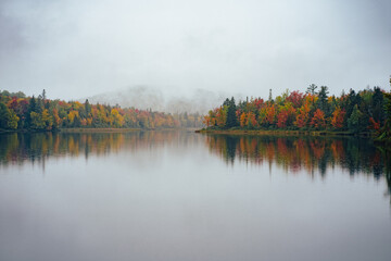Fog over colorful trees by the river in North Conway, New Hampshire