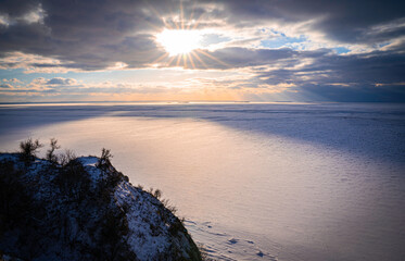 The sun at sunset and the rays of the sun falling on the frozen Dnieper River, view from Mount Pivikha