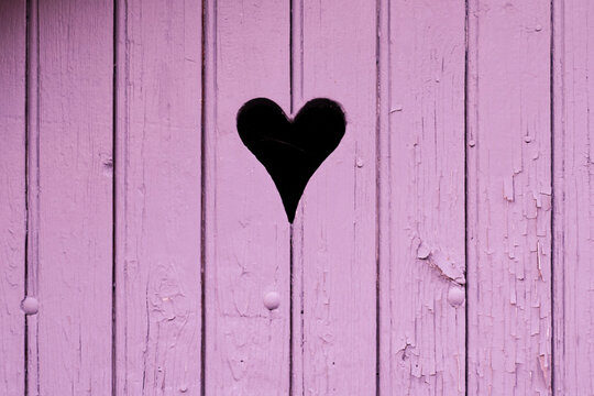 heart on pink plank wood perforation in the wooden door in the shape of love background