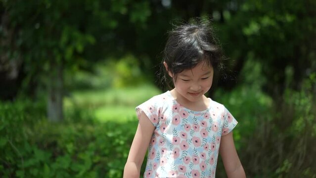 Shy asian Chinese girl 5 years old outdoor looking up