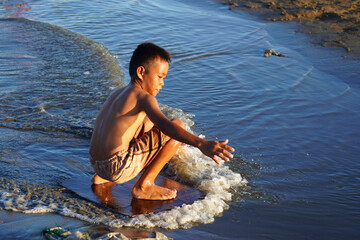 Fishing village playing at the beach on a waterboard. Bulalacao, Oriental Mindoro, the Philippines