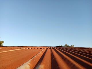 The roof of the house is rusted and is very old and dilapidated.